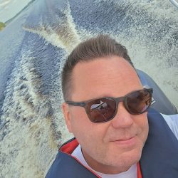 Tommi Kantosen selfie, jossa hän on veneilemässä aurinkolasit päässä.