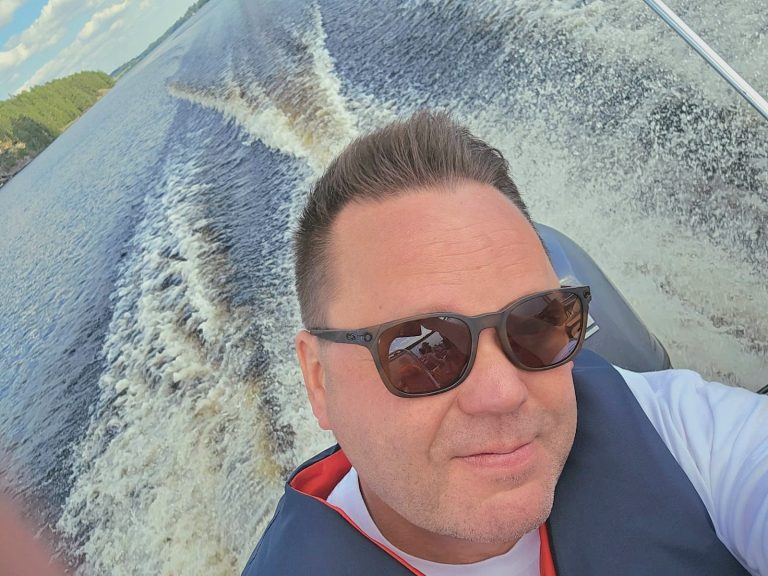 Tommi Kantosen selfie, jossa hän on veneilemässä aurinkolasit päässä.