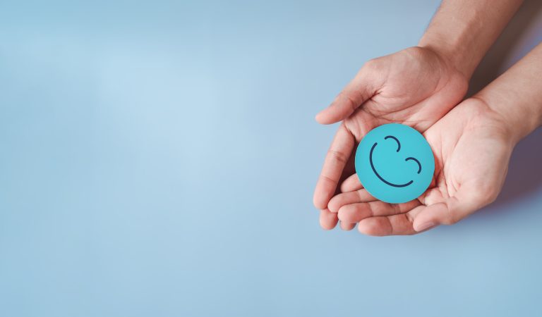 Kuvituskuva, vaaleansininen tausta, jonka päällä on avoinna olevat kämmenet ja niiden päällä positiivista palautetta kuvaa hymyilevä naama.