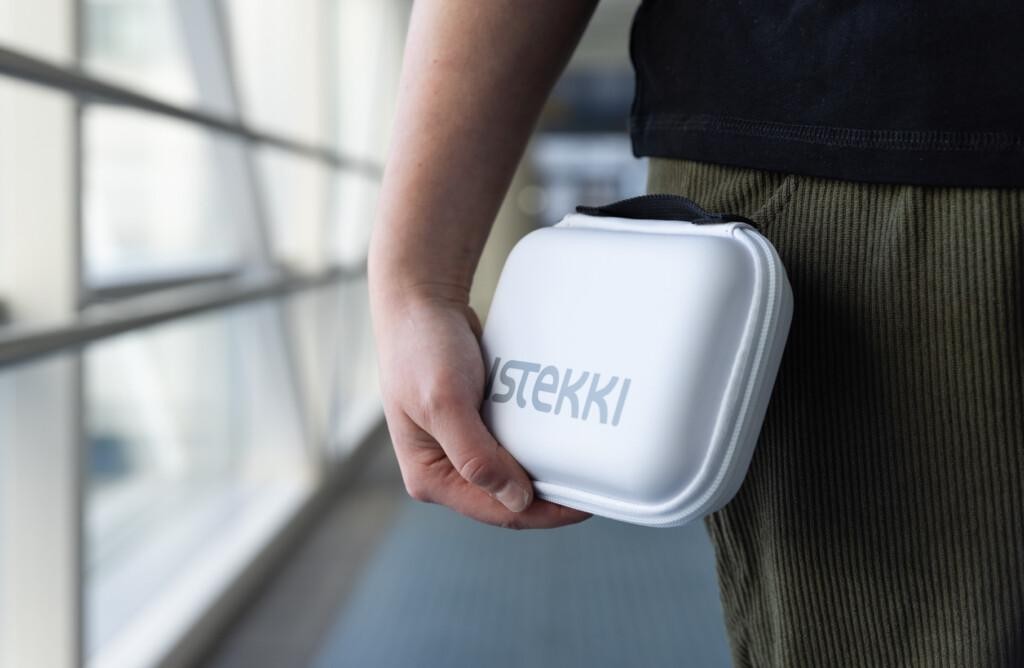 Istekilläinen kantaa valkoista Istekki-suojakoteloa kädessään käytävällä.