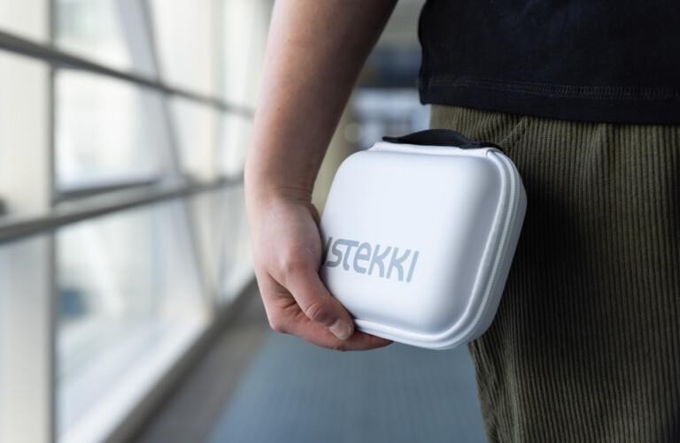 Istekilläinen kantaa valkoista Istekki-suojakoteloa kädessään käytävällä.